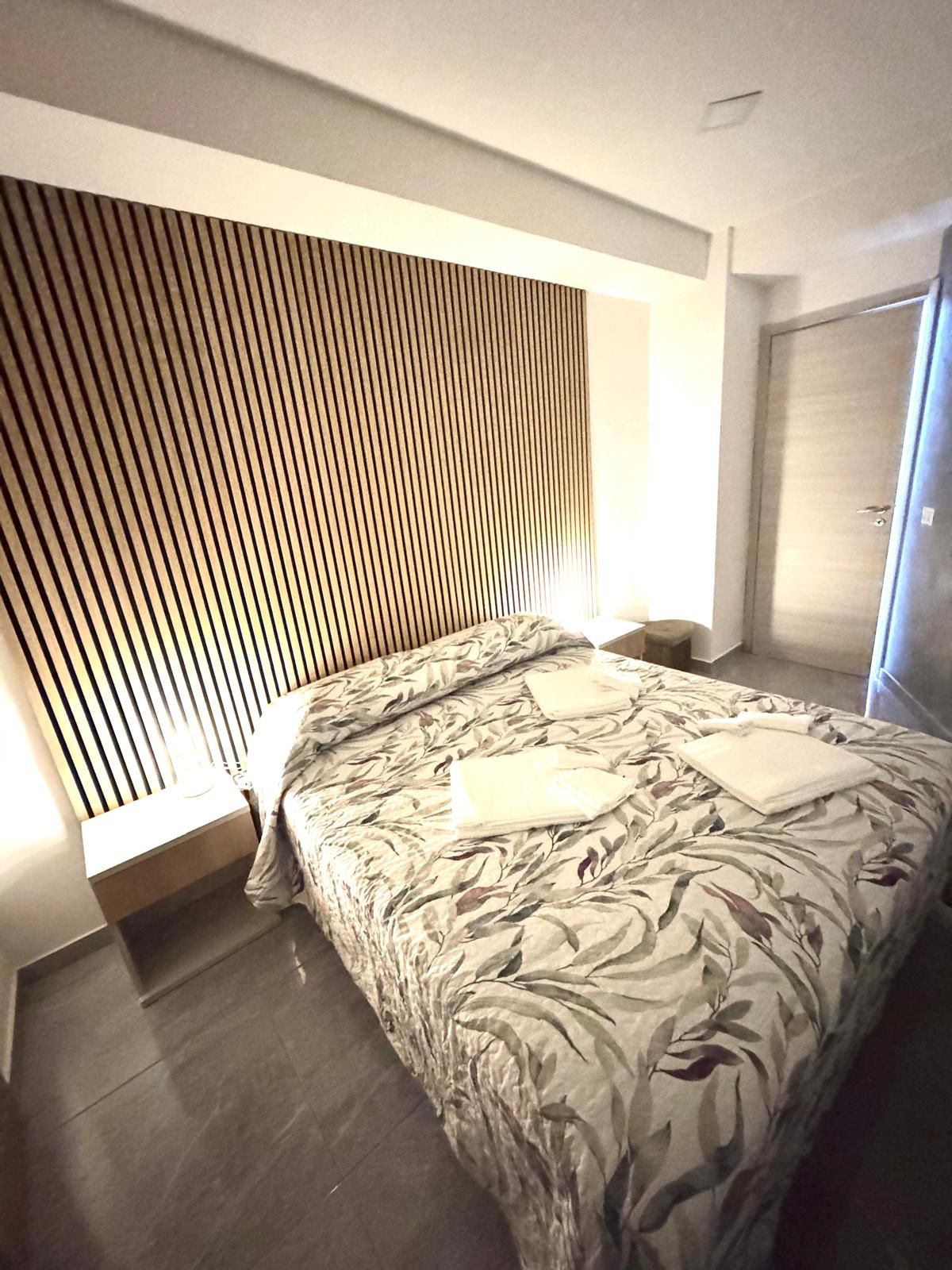 Bedroom with wardrobe and floral bedding in ALI APARTMENT