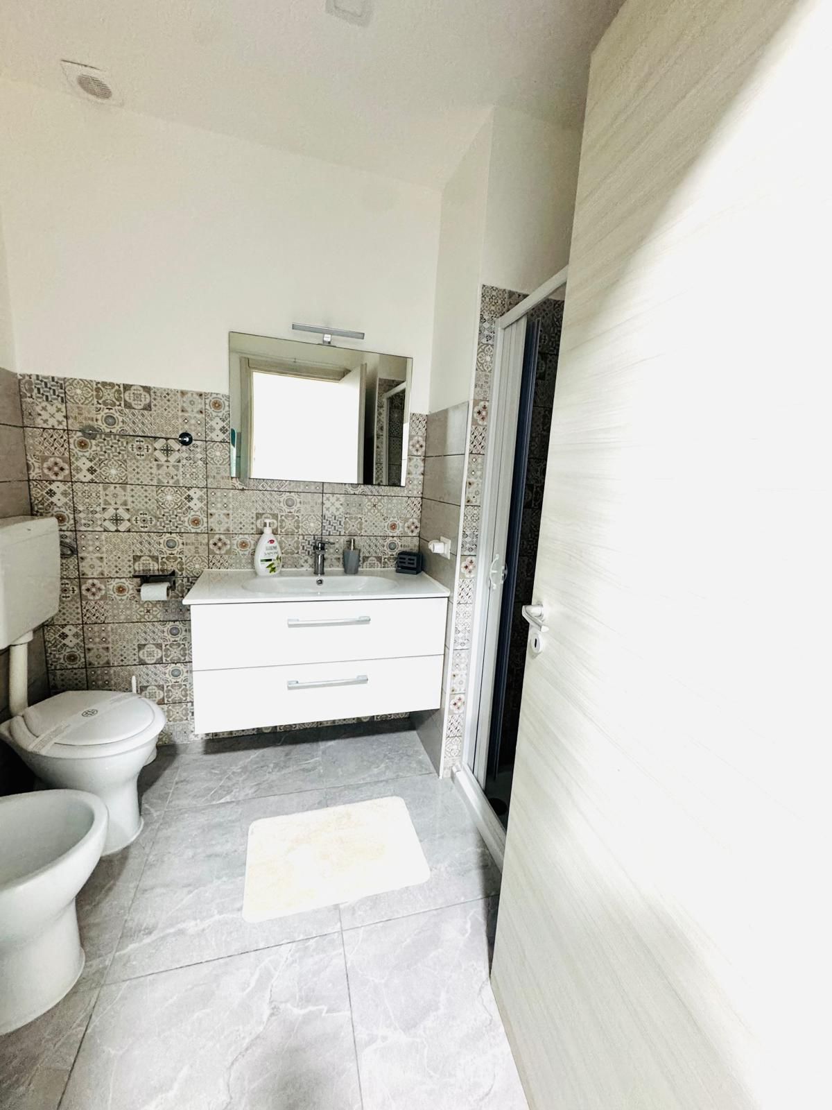Bathroom with patterned tiles and shower in the ALI APARTMENT